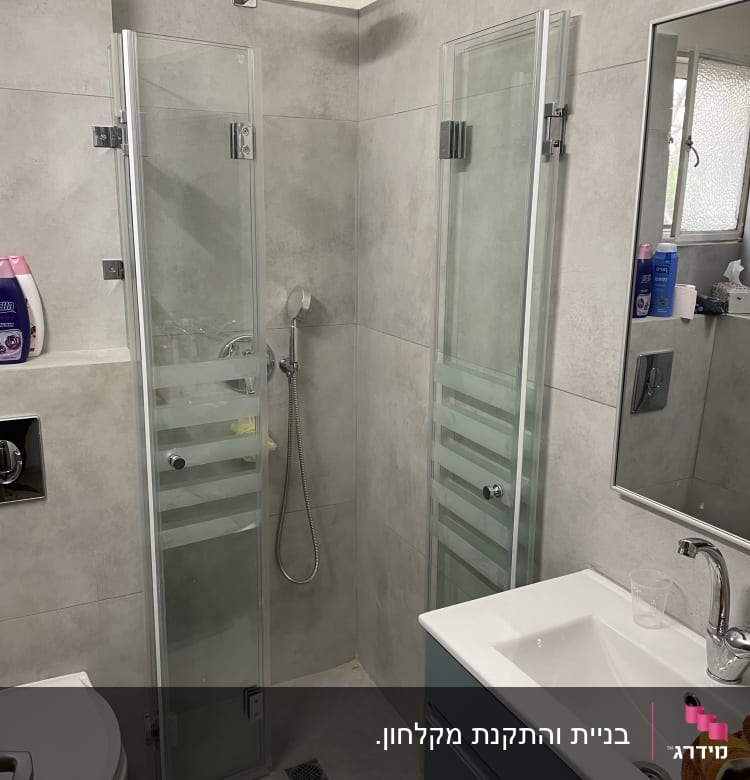 מקלחת עם דלתות זכוכית וברז גשם